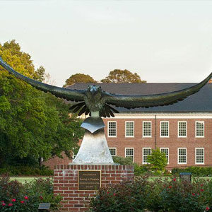 Statue of a large bird with its wings spread. There is a plaque beneath the bird.