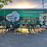 Wilmington movers pose ecstatically in front of moving truck.