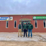 Three movers stand in front of the office of Storage Monkey and Little Guys Movers Lubbock.