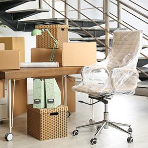 A cluster of boxes and furniture is placed near a staircase.
