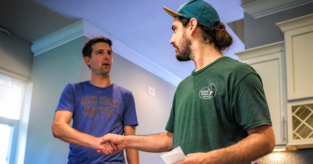 A Little Guys Movers mover shakes hands with a McKinney customer.