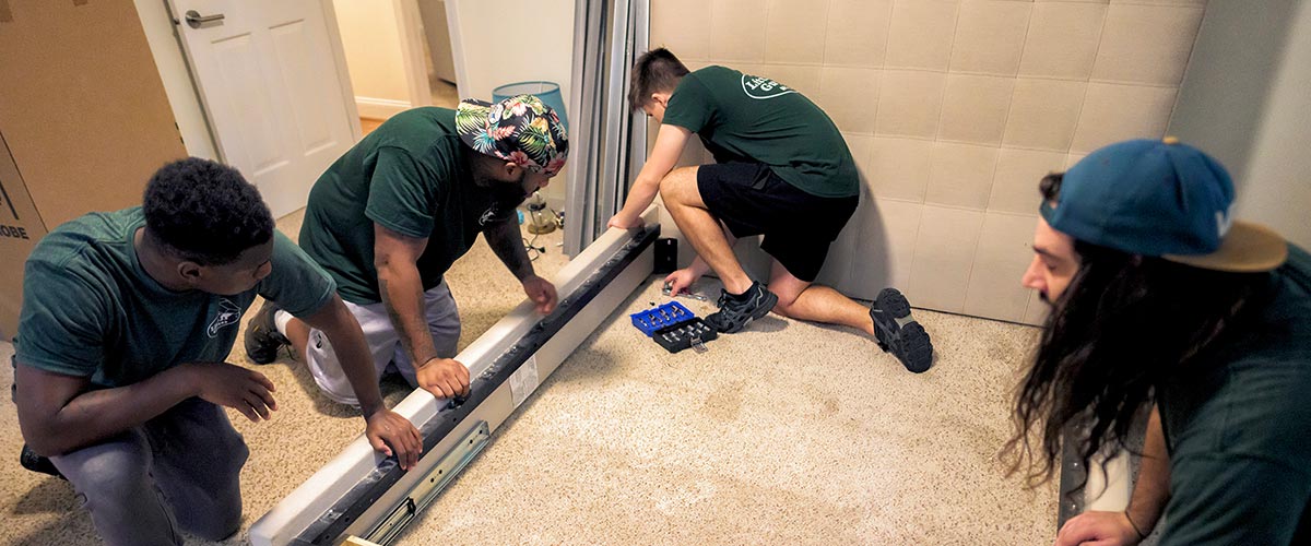 Four Little Guys Movers movers reassemble a bed in their customer's new apartment