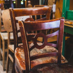 Close up of weathered and worn wooden chairs that are ready to be donated